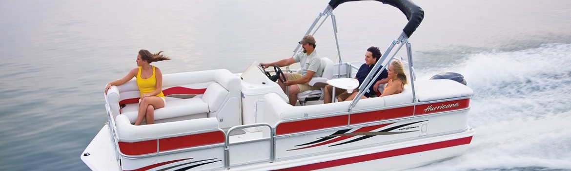 Four people riding a red and white boat through the water, with one person sitting in the front.