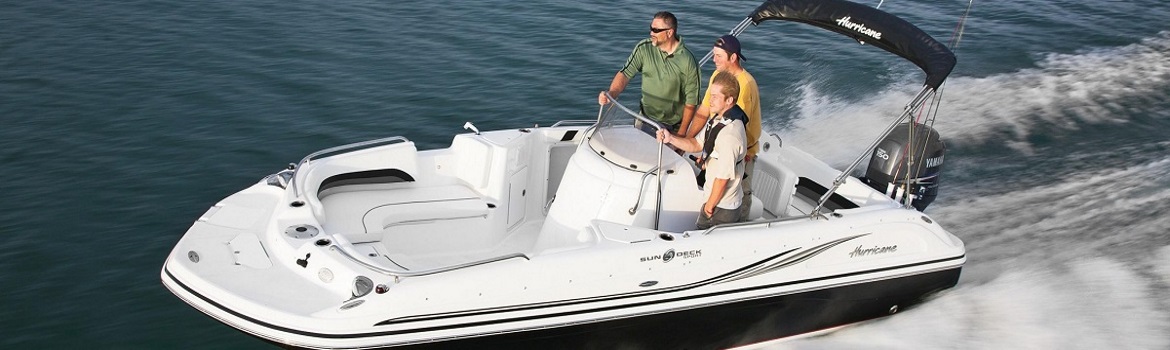 Three men on a white boat cruising on the water.