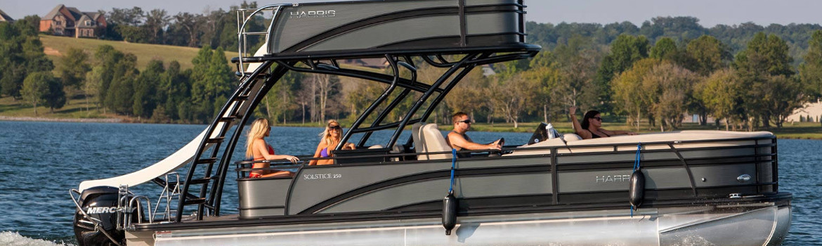 Four people relaxing on a grey boat in the middle of the water.